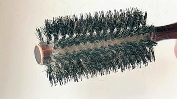 An old comb with a lot of fallen hair on a white background. video