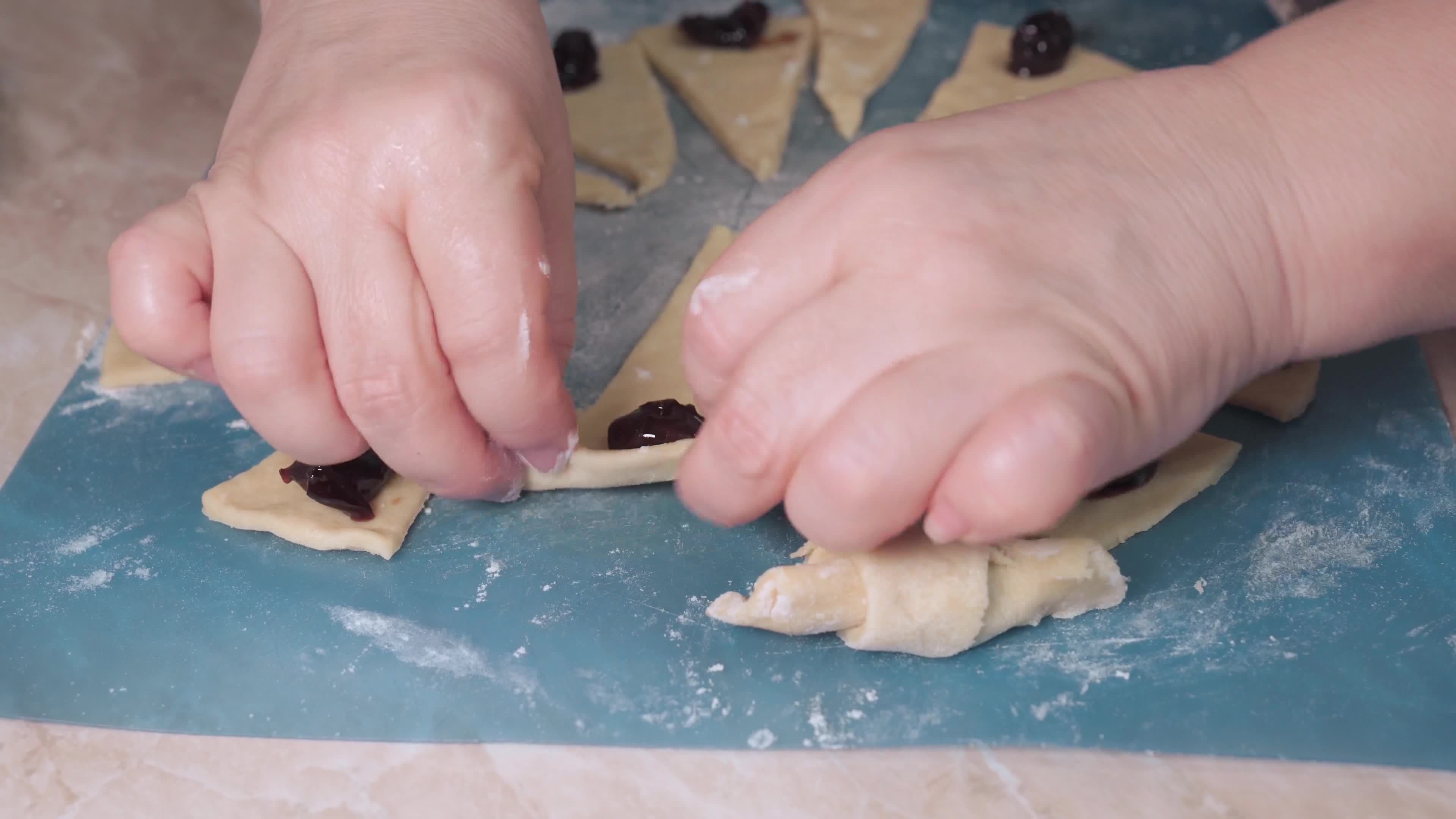Women's hands wrap the filling in the dough when making homemade