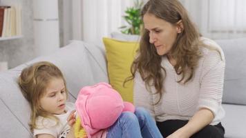 The mother is trying to talk to her little daughter. The little girl does not talk to her mother and does not care about her. video