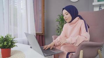 Muslim Turkish schoolgirl using laptop. Muslim teenage girl in hijab looking at laptop and thoughtful. video