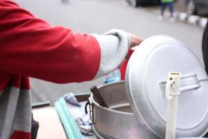 man street food seller serving the Indonesian traditional green bean porridge on his silver cart photo