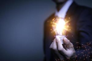 Businessman holding a light bulb, Creative new idea. Innovation, brainstorming, solution and inspiration concepts. imagination, creative thinking problem solving... photo