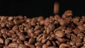 slow motion van gebrande koffiebonen vallen. biologische koffie zaden. video