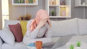 Muslim woman looking at laptop is stressed and bored. Stressed Muslim woman looking at laptop and feeling bored. video