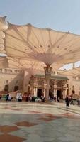medina, saudita Arábia, 2022 - guarda-chuva construção em a quadrado do al-masjid an-nabawi ou profeta Muhammed mesquita estão protegendo pessoas a partir de Sol às a dia e trabalho Como luzes às noite video