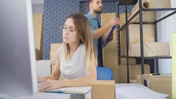 Couple online entrepreneurs working in small online store office. Working couple online entrepreneur and woman checking store order with computer. video