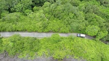 Drone shot of passing jeet with kayak on concrete road between forest video