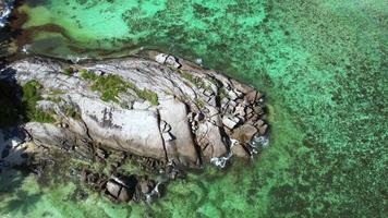 Bird eye drone shot at Anse forbans beach, people walking on huge granite rock Mahe Seychelles video