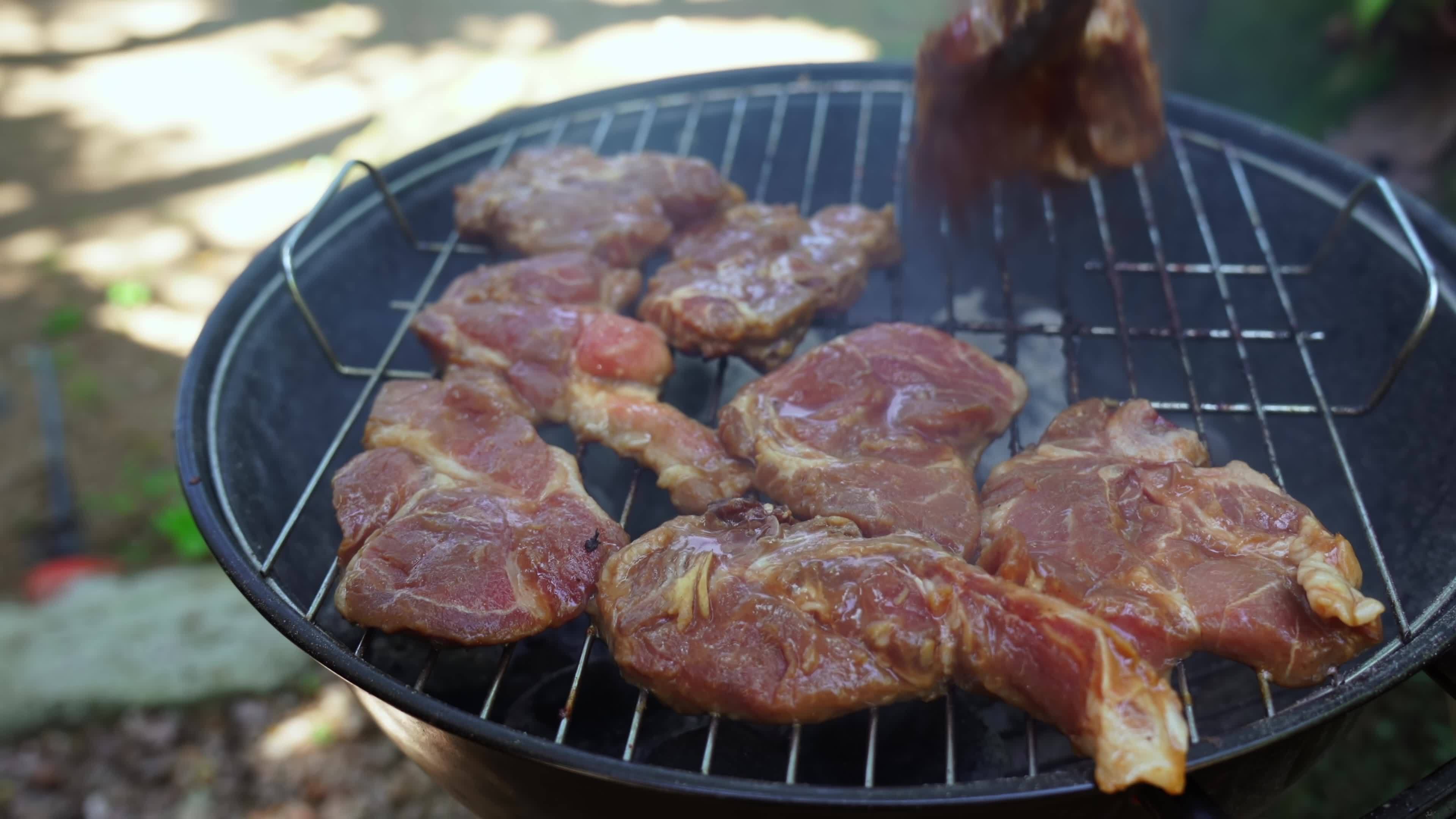 Putting pork chops on home charcoal bbq grill 21361791 Stock Video at