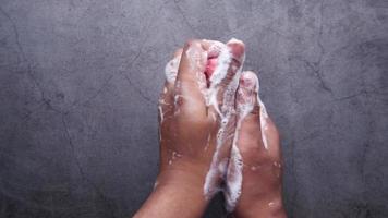 young man washing hands with soap warm water video