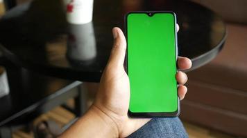 utilizando inteligente teléfono con verde pantalla en escritorio video