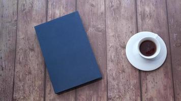 copo do uma café e azul livro em de madeira mesa video