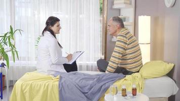 kvinna läkare granskning och kontroll henne patient liggande i säng. kvinna läkare tar vård av sjuk man liggande i säng, de prata handla om sjukdom. video
