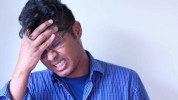 Young man suffering headache, close up video