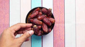 man reaching for date fruits on table video