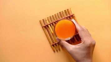 Orange Saft im Glas auf ein Farbe Hintergrund video