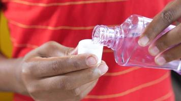 Hand hold a mouthwash liquid container on yellow background video