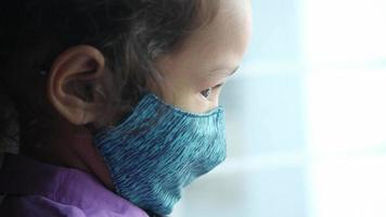 an upset child girl with face mask looking down video