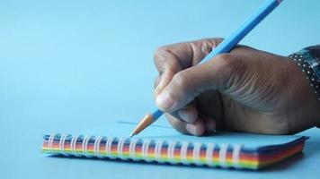 Person hand holding pencil against blue background video