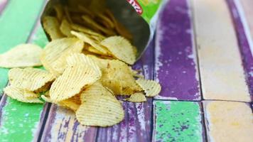 tasty potato chips on colorful wooden backgroun video