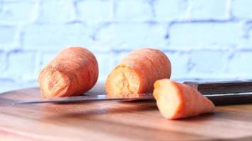 Top view of man hand cutting carrot on chopping board video