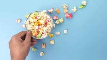 smakelijk popcorn morsen van een kom Aan blauw achtergrond video