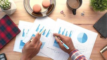 Man hand with pen analyzing bar chart on paper video