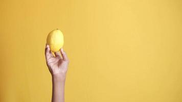 mano recoger amarillo limón desde un plato en amarillo antecedentes video