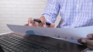 Man hand with pen analyzing bar chart on paper video