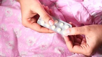 Man hand taking pills from blister pack top down video