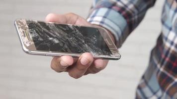 Close up of man hand holding broken smart phone video