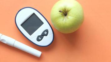 diabetic measurement tools, apple on orange background video