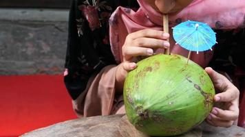 jung Frau Trinken frisch Kokosnuss auf ein Tabelle video