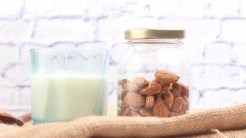 Close up of almond nut and milk on table video