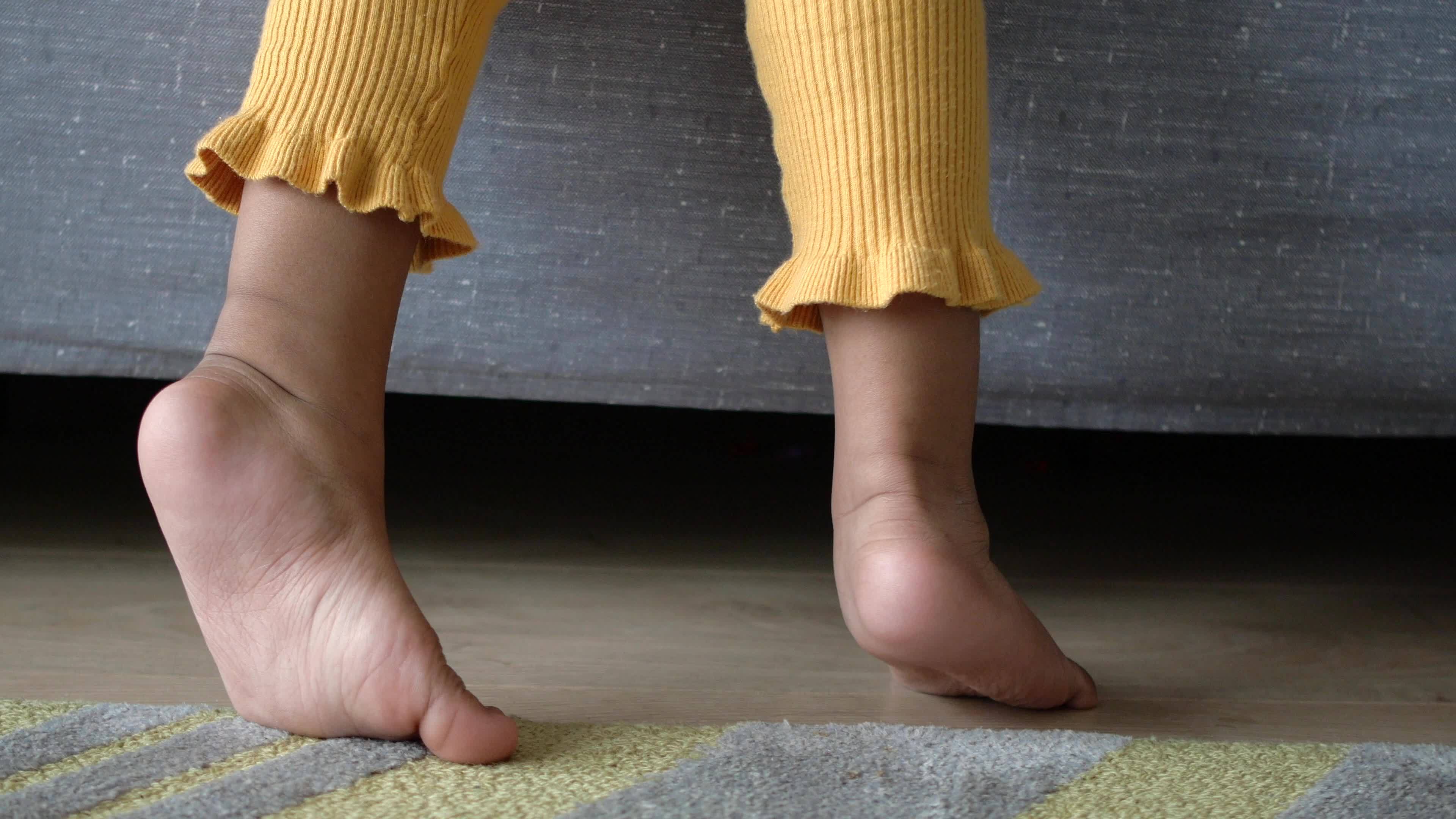 Low angle view of a child walking on tiptoes 21366012 stock video at