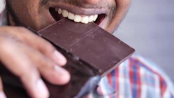 jovem comendo chocolate amargo close-up video