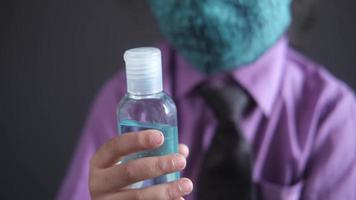 barn i skola klänning i ansikte mask innehav hand desinfektionsmedel video