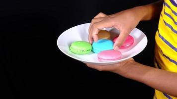 Slow motion of hand pick macaroon from a plate video