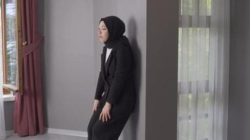 Depressed young muslim woman crying while leaning against the wall. Business woman in black hijab is crying. video