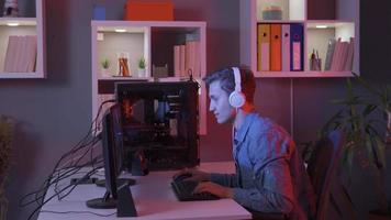 jovem homem jogando vídeo jogos em dele computador regozija-se e vitórias. jovem jogador jogando conectados vídeo jogos. video