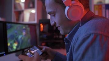 jong knap pro speler spelen online mobiel spel met slim telefoon. jong Mens spelen spel Aan smartphone is ondergedompeld. video