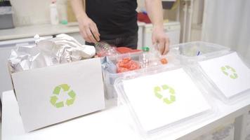reciclando às lar. decomposição. a homem Ordenação desperdício dentro a cozinha. isto separa vidro, plástico e papel.