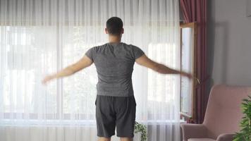 Handsome active young man doing cardio in living room. Attractive male in sportswear spends leisure time exercising and exercising at home on weekends. Healthy life concept. video