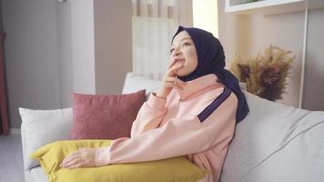 Muslim woman in hijab is dreaming, thinking, looking for ideas. Muslim woman in hijab dreams at home.