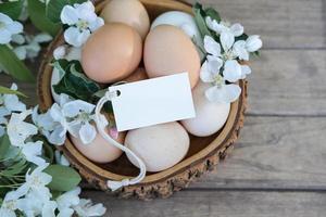 de madera cuenco con Pascua de Resurrección huevos y blanco blanco tarjeta para texto. Pascua de Resurrección tarjeta foto