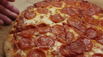 oben Aussicht von Mann Hand nehmen Scheibe von Pizza mit Käse, Tomaten von Essen Lieferung.