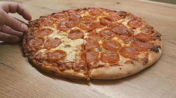 Top view of man hand taking slice of pizza with cheese, tomatoes from food delivery. video