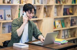 Young Asian man studying at library photo