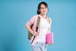 Young Asian student on blue background photo