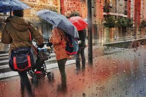 Bilbao, Vizcaya, Spain, 2022 -  people with an umbrella in rainy days in winter season, bilbao. photo